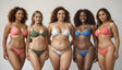 Five women stand confidently, each wearing vibrant bikinis in shades of pink, green, floral, blue, and coral. Their diverse skin tones and hairstyles, ranging from natural curls to sleek waves, highlight their individuality. Smiling expressions radiate confidence, while the neutral background draws focus to the vivid swimwear and their natural beauty. Ai generated. Photography style.
