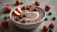 A creamy smoothie bowl swirled with a vibrant purple hue and a touch of yogurt on top. The dish is adorned with fresh halved strawberries, juicy blueberries, plump raspberries, and crunchy granola. The rustic, textured bowl rests on a gray surface scattered with additional berries and oats, emphasizing a wholesome and inviting presentation. Ai generated. Photography style.