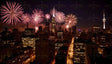 A brilliant display of pink and red fireworks illuminates the night sky above a bustling urban skyline. The towering skyscrapers, including a prominent lit spire, stand out against the festive lights. The city streets below glow with the golden hues of streetlights, reflecting the celebratory mood. This stunning scene captures the essence of a joyous metropolitan celebration. Ai generated image.