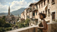 A woman in a green dress and sunglasses stands on a stone balcony, overlooking a picturesque town. Nearby buildings feature warm beige facades, shuttered windows, and balconies. A prominent dome and tall church spire rise in the background, framed by rolling green hills under a bright blue sky with scattered white clouds. Palm trees and greenery enhance the serene atmosphere. Ai generated. Photography style.