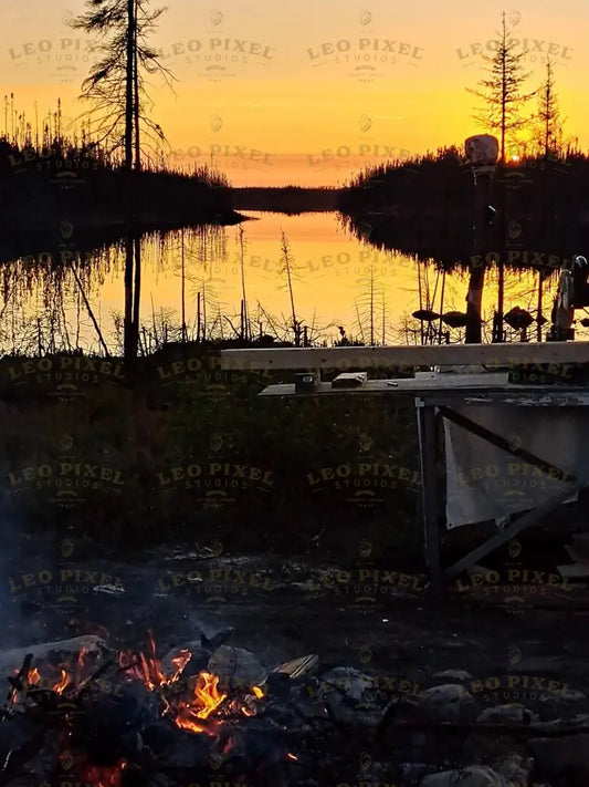 Sunset on a lake with a burning outdoor fire on a deserted island