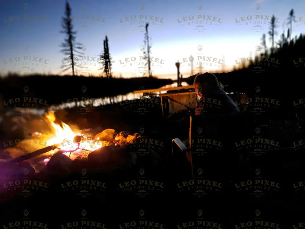 Woman Near A Campfire And Lake At Sunset Stock Photos